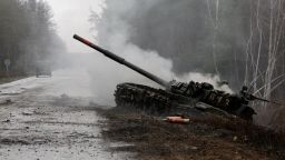 TOPSHOT - Smoke rises from a Russian tank destroyed by the Ukrainian forces on the side of a road in Lugansk region on February 26, 2022. - Russia on February 26 ordered its troops to advance in Ukraine "from all directions" as the Ukrainian capital Kyiv imposed a blanket curfew and officials reported 198 civilian deaths. (Photo by Anatolii Stepanov / AFP) (Photo by ANATOLII STEPANOV/AFP via Getty Images)