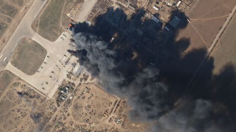 A satellite image shows a large black plume of smoke rising from the Kherson International Airport on Tuesday, March 15. When zoomed in, the satellite images show a number of helicopters are on fire.