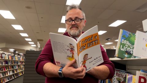 Toby Price reads a copy of the children's book "I Need a New Butt!" He was fired for reading the book to a second-grade class on March 2, 2022. 