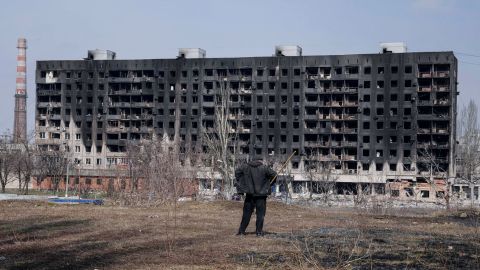 A man looks at a burned apartment building that was damaged by shelling in Mariupol on Sunday.