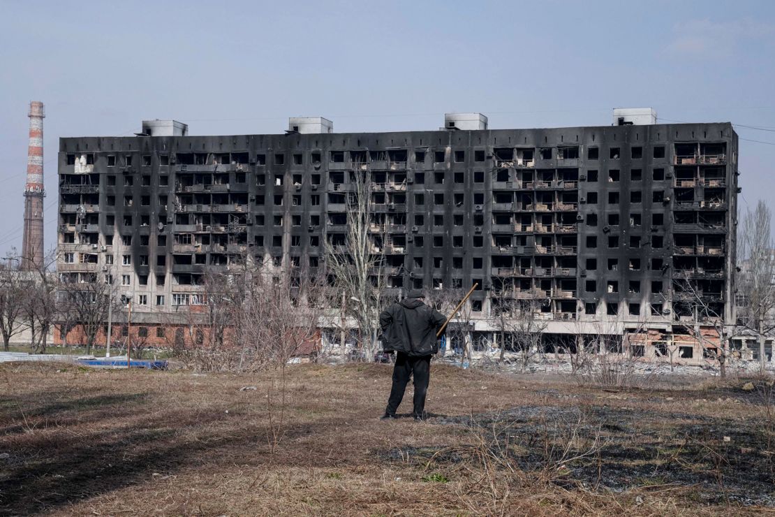 A man looks at a burned apartment building that was damaged by shelling in Mariupol on Sunday.