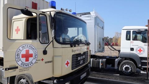 International Committee of the Red Cross trucks wait in line Monday at the Siret border crossing in Romania on their way to deliver aid to Ukraine, in this still image taken from a video.