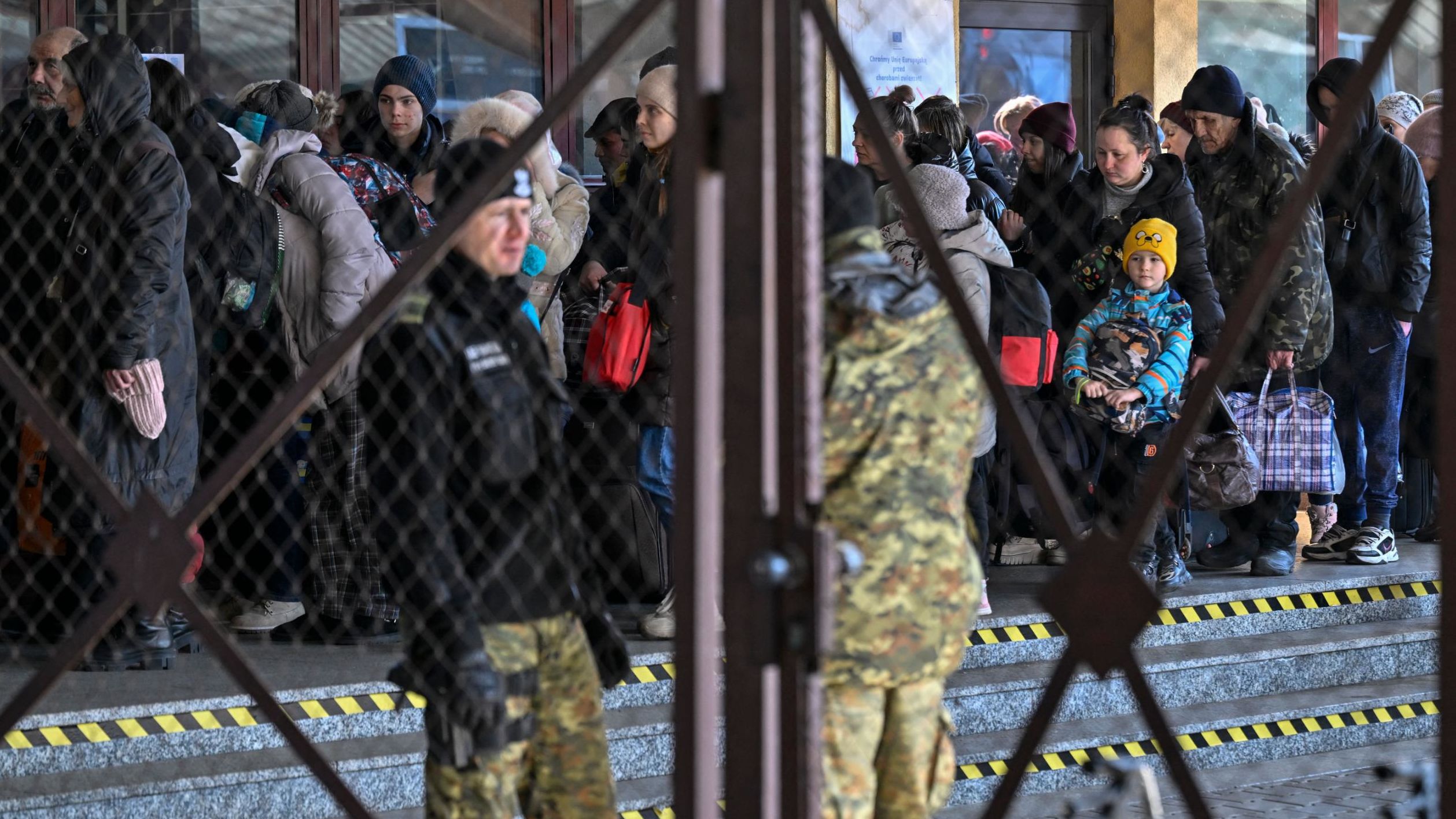People line up Monday after arriving from Ukraine at the train station in Przemysl, near the Ukrainian-Polish border.
