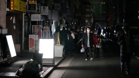 People walk on a street during a blackout in Tokyo.