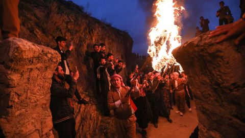 People holding lit torches walk up a mountain during celebrations of Nowruz, the Persian New Year, in the town of Akra in Iraq's northern autonomous Kurdish region in March 2021. 