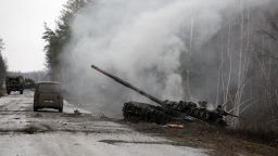 Smoke rises from a Russian tank destroyed by the Ukrainian forces on the side of a road in Lugansk region on February 26, 2022. - Russia on February 26 ordered its troops to advance in Ukraine "from all directions" as the Ukrainian capital Kyiv imposed a blanket curfew and officials reported 198 civilian deaths. (Photo by Anatolii Stepanov / AFP) (Photo by ANATOLII STEPANOV/AFP via Getty Images)