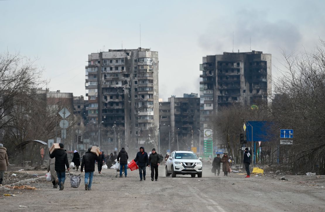 Refugees carrying their personal belongings leave Mariupol. While some have been able to leave, Ukrainian officials say others have been involuntarily taken to Russia.