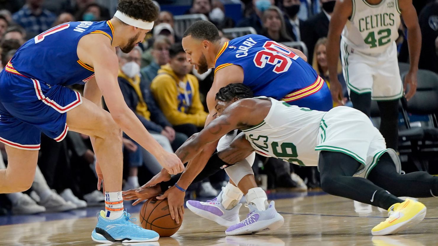 Marcus Smart reaches for the ball against Steph Curry during the first half of the game between the Warriors and the Celtics.