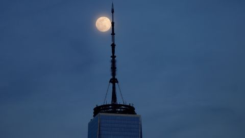 The worm moon, 98% illuminated, rises behind One World Trade Center in New York City on March 16, 2022, as seen from Jersey City, New Jersey.  