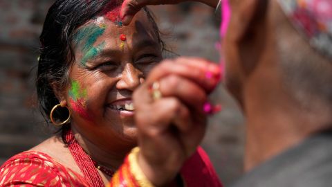 Ludzie nakładają na siebie kolorowy proszek podczas obchodów Holi w Bhaktapur, Nepal, 17 marca 2022 r.
