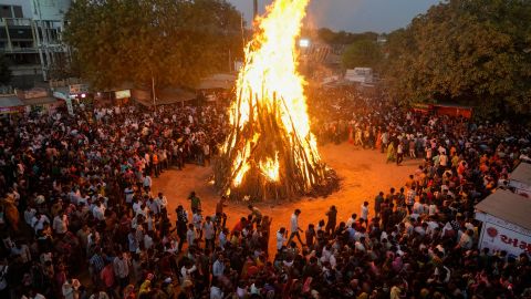 Obserwatorzy w Ahmedabadzie w Indiach świętują Holika Dahan w 2022 roku przy ognisku.