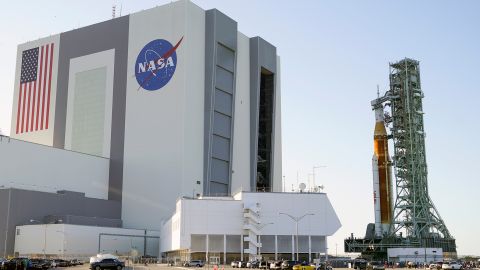 The NASA Artemis I stack, including the SLS rocket (right) topped with the Orion spacecraft, leaves the Vehicle Assembly Building at Kennedy Space Center in Florida on March 17.