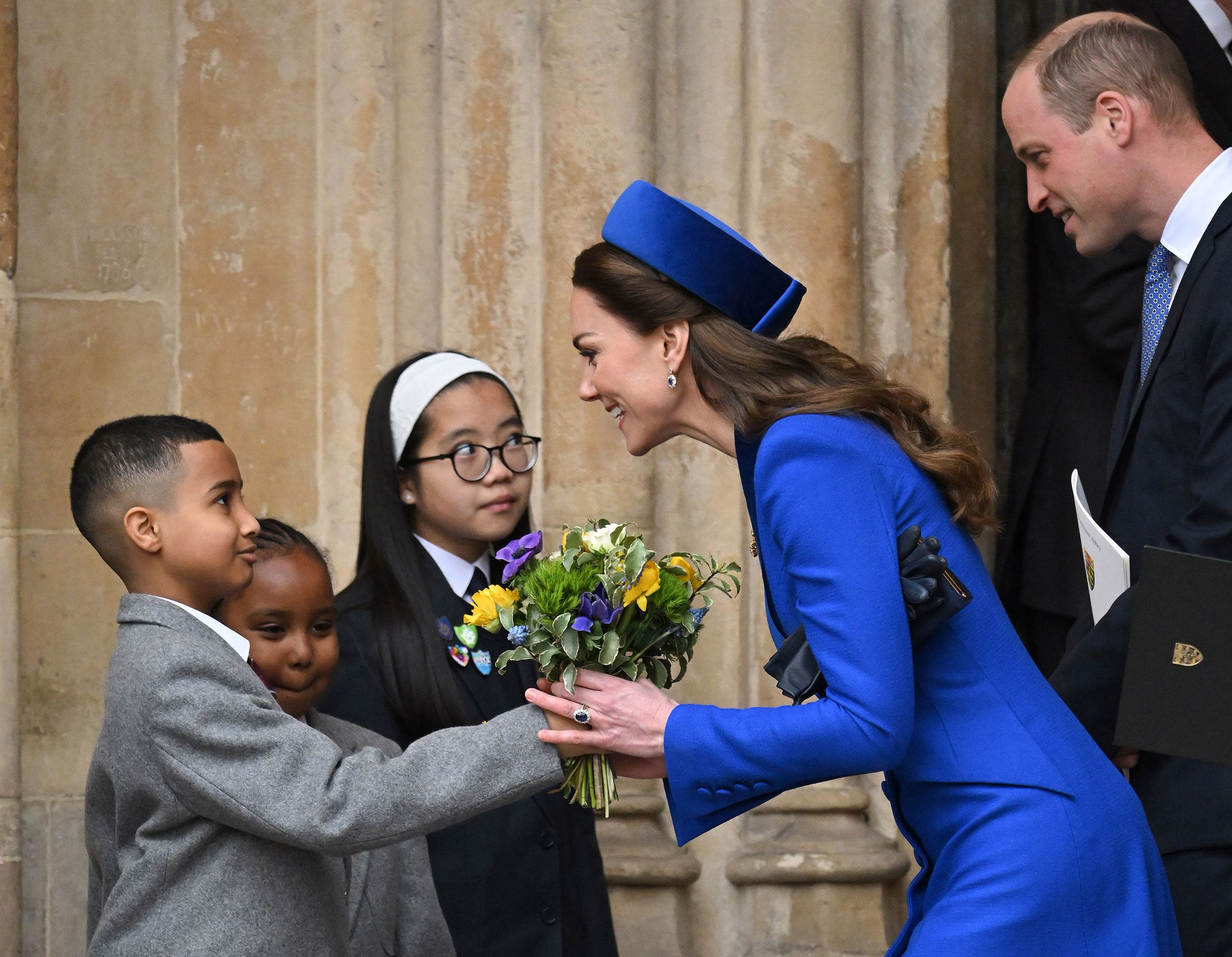 Catherine, the Duchess of Cambridge, accepts flowers from children as she and her husband, Prince William, attend a Commonwealth Day service at Westminster Abbey in London on Monday, March 14.