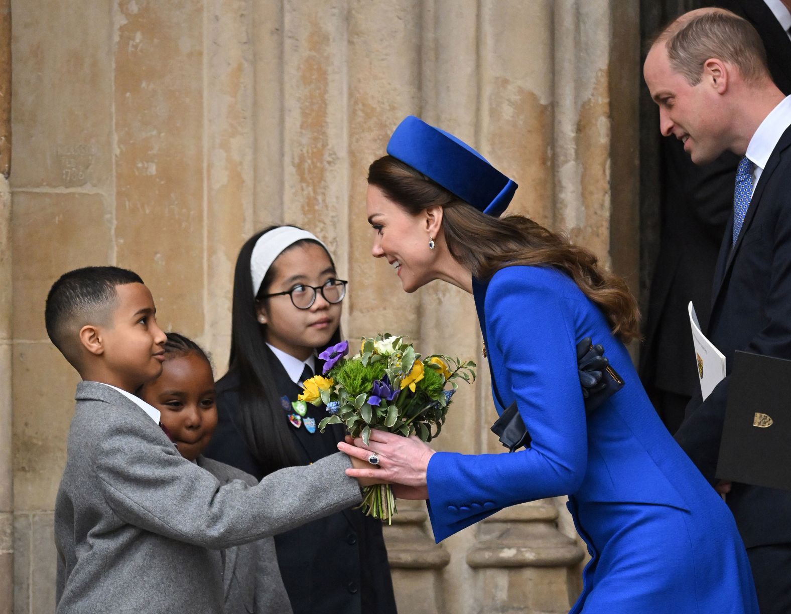 Catherine, the Duchess of Cambridge, accepts flowers from children as she and her husband, Prince William, attend a Commonwealth Day service at Westminster Abbey in London on Monday, March 14.