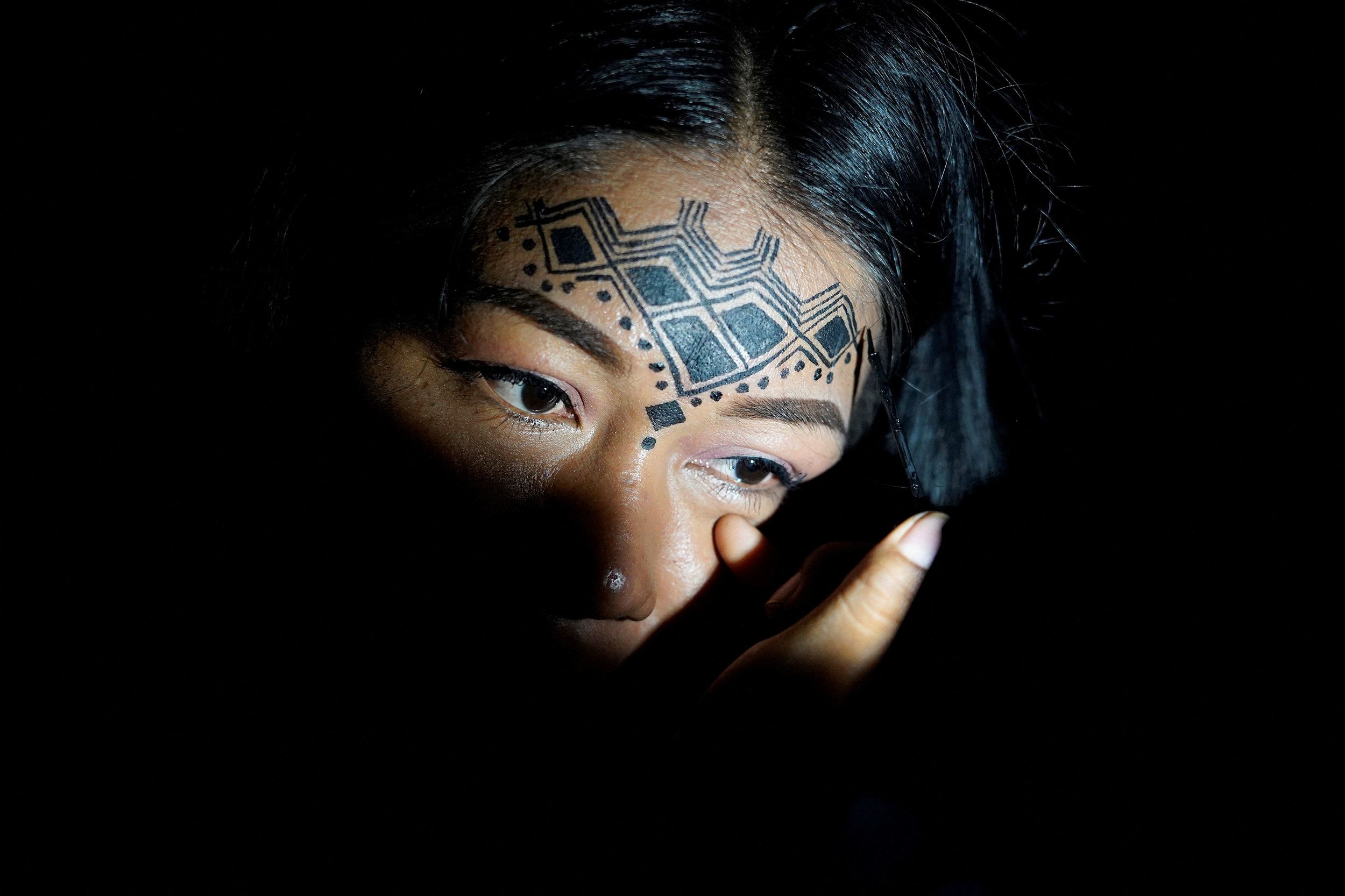 A woman wears face paint in Puyo, Ecuador, on Tuesday, March 15. Indigenous communities from the Amazon basin were meeting in Puyo to demand that South American governments halt extractive industries that damage the rainforest.