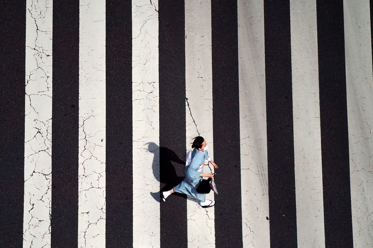 A woman wears a protective mask and a traditional Japanese kimono as she crosses a street at the Ginza shopping district in Tokyo on Wednesday, March 16.