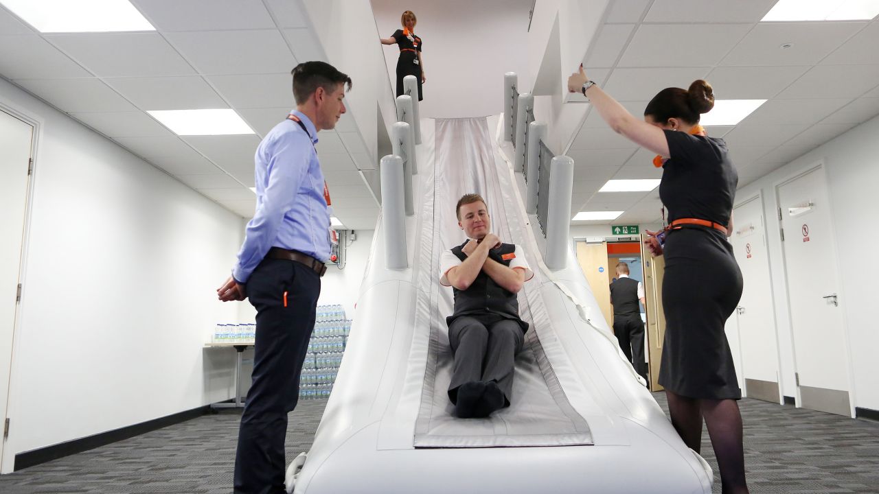 An employee practices an emergency evacuation using an aircraft slide at the opening of EasyJet Plc's new European training facility at London Gatwick Airport in 2015. 