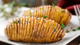 Thinly sliced Hasselback potatoes with herbs offer more flavor than a plain baked spud.