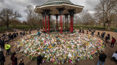 People look at flowers placed in tribute to Sarah Everard on Clapham Common in London on March 15, 2021. 