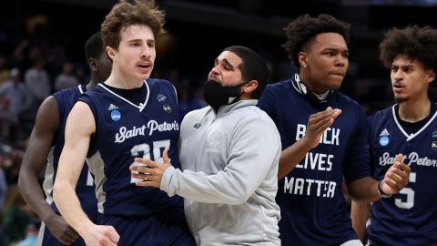 Doug Edert of the Saint Peter's Peacocks celebrates with his teammates after making a three-pointer against the Kentucky Wildcats.