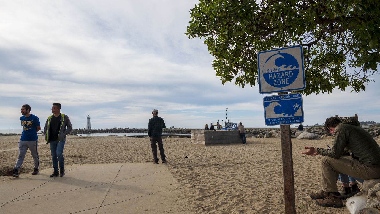 People watch waters rise from beaches in Santa Cruz, California, amid a tsunami advisory following the Tonga volcanic eruption.