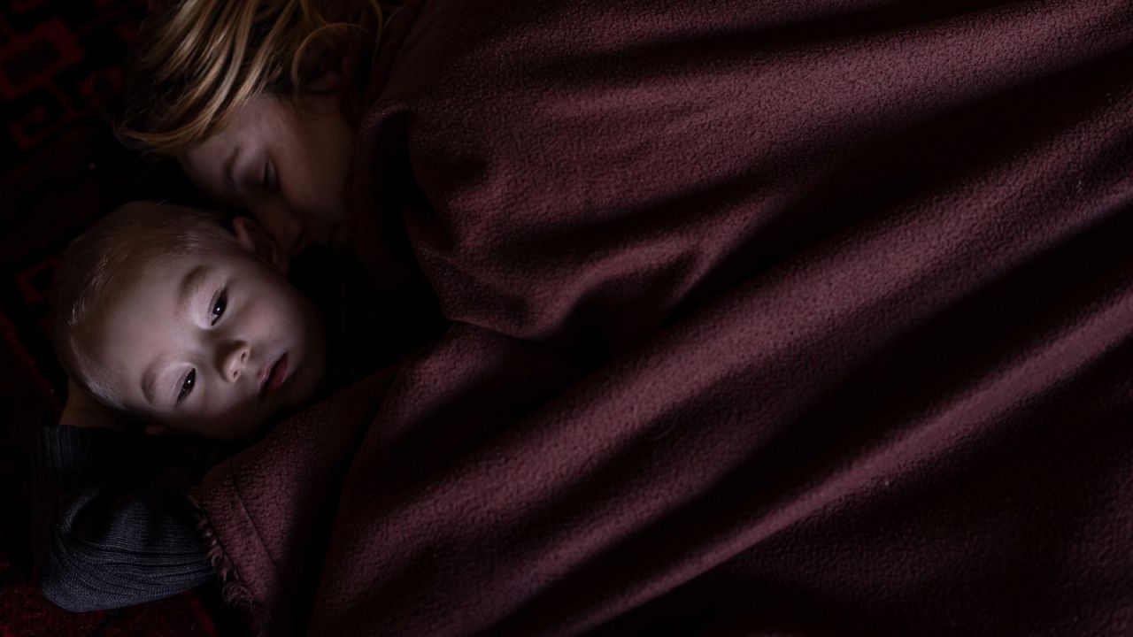 A mother and son rest in Lviv, Ukraine, while waiting to board a train to Poland on March 12.