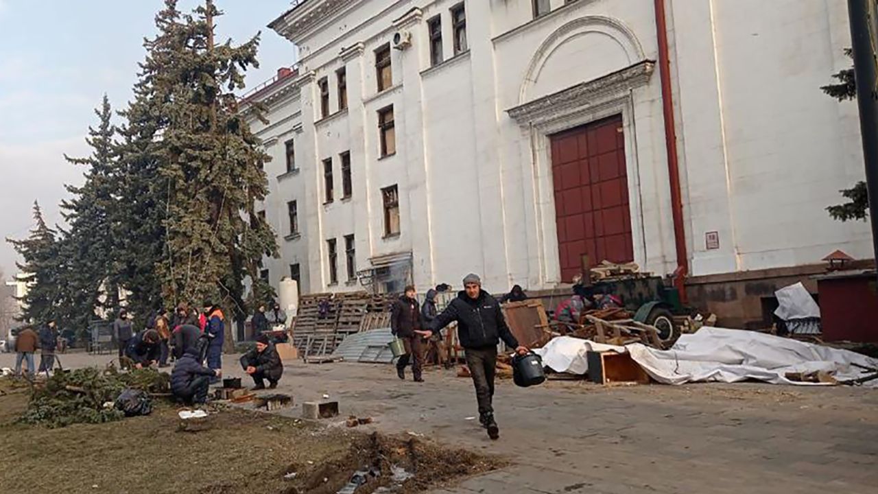 A photo taken outside the Drama Theater before it was bombed, where people were burning branches and debris to keep warm.