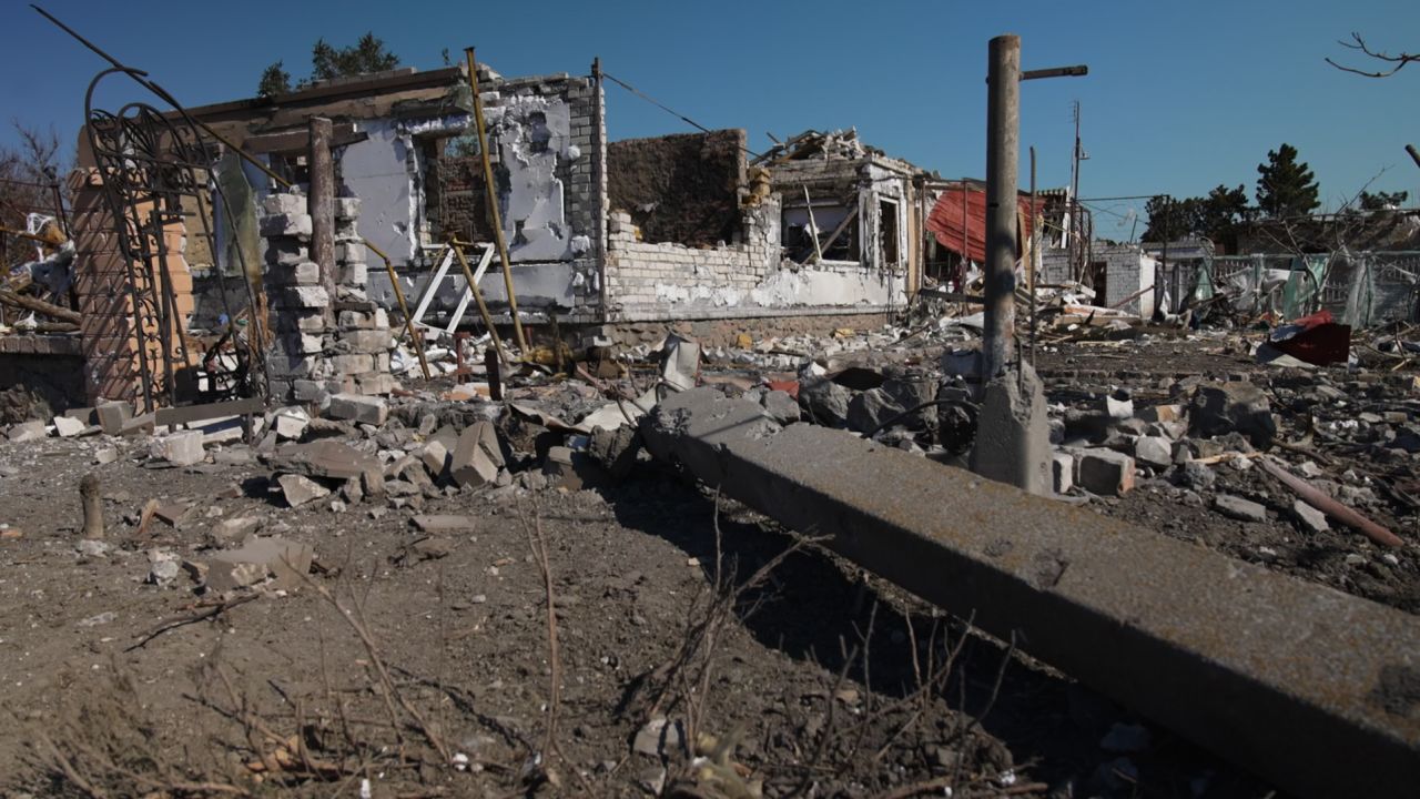 Buildings are scarred with shell impacts from intense fighting.
