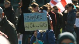 A protester holds a sign calling for an "embargo of oil and gas" during an anti-war protest demanding more sanctions against Russia in Duesseldorf, Germany on March 19, 2022.