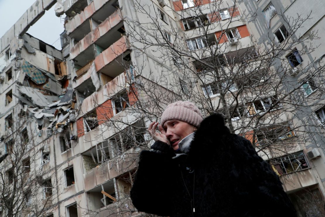 A Ukrainian woman near a block of apartment buildings destroyed in the besieged port city of Mariupol on March 17, 2022.