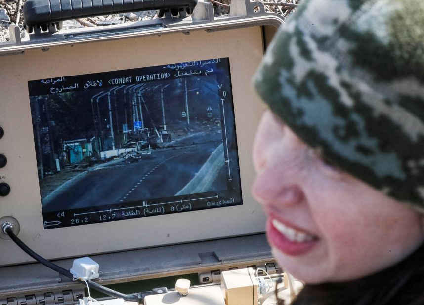 Former Ukrainian Parliament member Tetiana Chornovol, now a service member and operator of an anti-tank guided missile system, examines a Russian tank she destroyed in a recent battle in the Kyiv region.