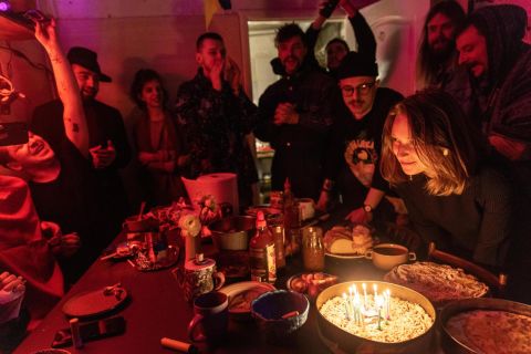 People share dinner and sing "Happy Birthday" during a celebration in Kyiv on Sunday, March 20. This studio space has turned into a bomb shelter for approximately 25 artists who are volunteering to help the war effort. 