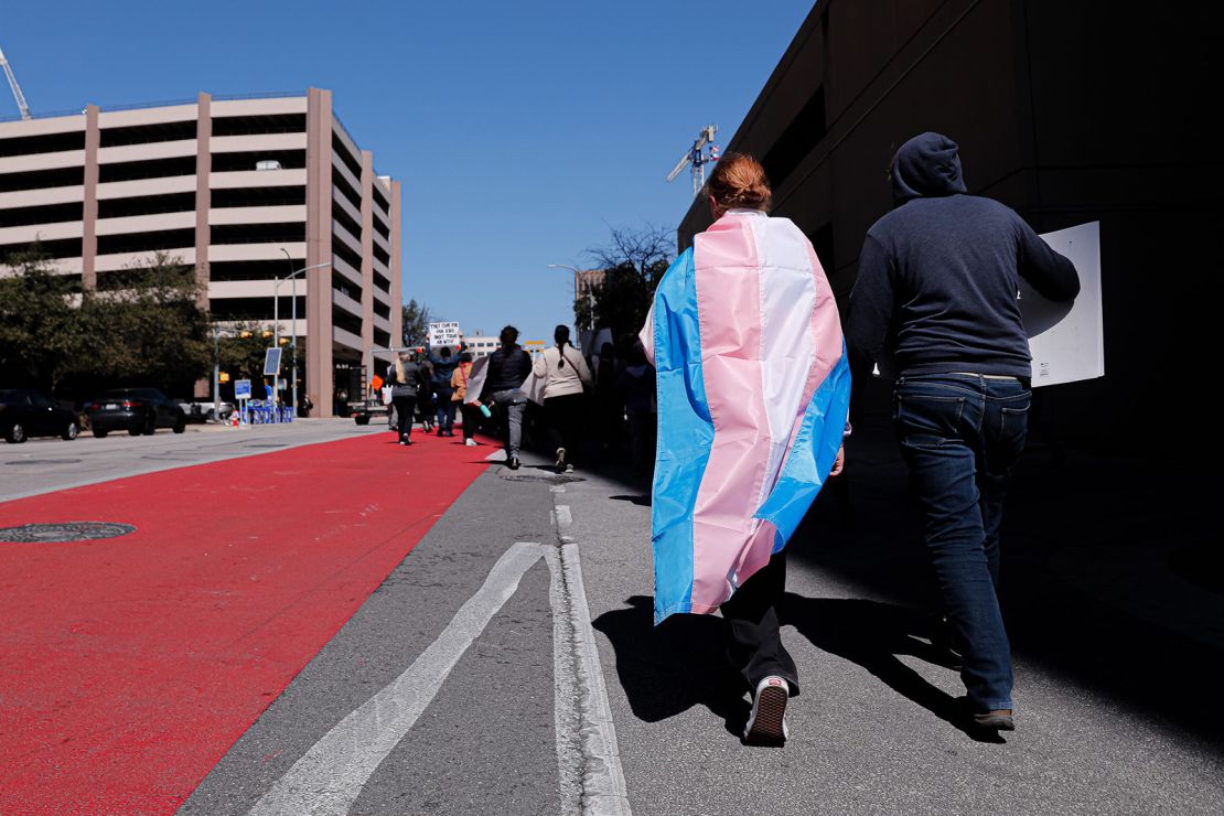 Dylan Yeary (left) wears the trans flag during a rally for trans rights that marched through the streets of  Austin, Texas, in February.