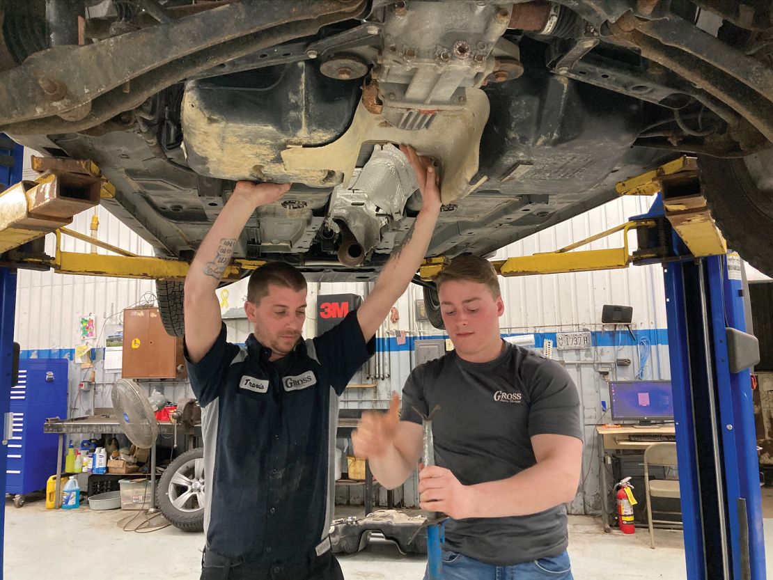 Travis Lewis, left, begins replacing the damaged gas tank at Gross Auto Group in Neillsville, Wisconsin.