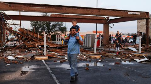Arturo Ortega and his son Kaysen, 2, survey the damage Monday to a shopping center after a reported tornado touched down in Round Rock, Texas. 