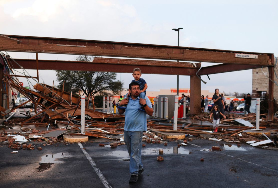 Arturo Ortega and his son Kaysen, 2, survey the damage Monday to a shopping center after a reported tornado touched down in Round Rock, Texas. 