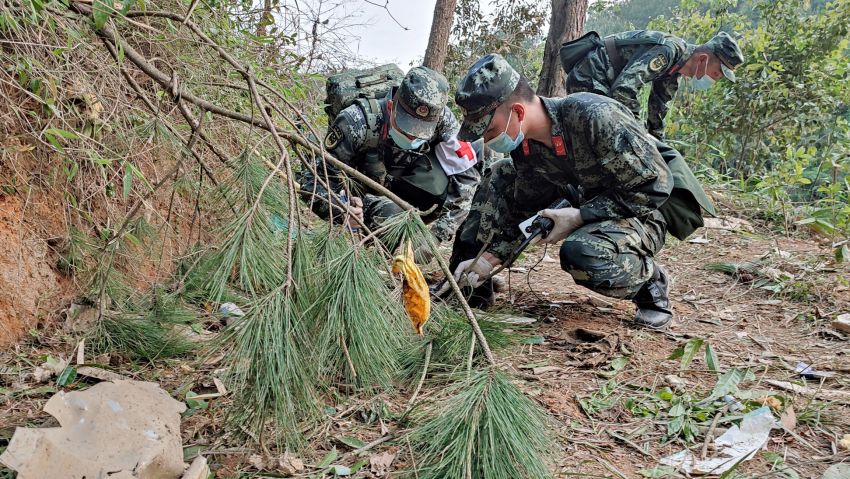 This photo taken on March 21, 2022 shows paramilitary police officers conducting a search at the site of the China Eastern Airlines plane crash in Tengxian county, Wuzhou city, in China's southern Guangxi region. - A China Eastern passenger jet carrying 132 people crashed onto a mountainside in southern China on March 21 causing a large fire, shortly after losing contact with air traffic control and dropping thousands of metres in just three minutes. - China OUT (Photo by CNS / AFP) / China OUT (Photo by -/CNS/AFP via Getty Images)