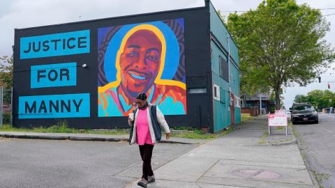 A woman walks past a mural honoring Manuel "Manny" Ellis, on Thursday, May 27, 2021, in the Hilltop neighborhood of Tacoma, Washington.