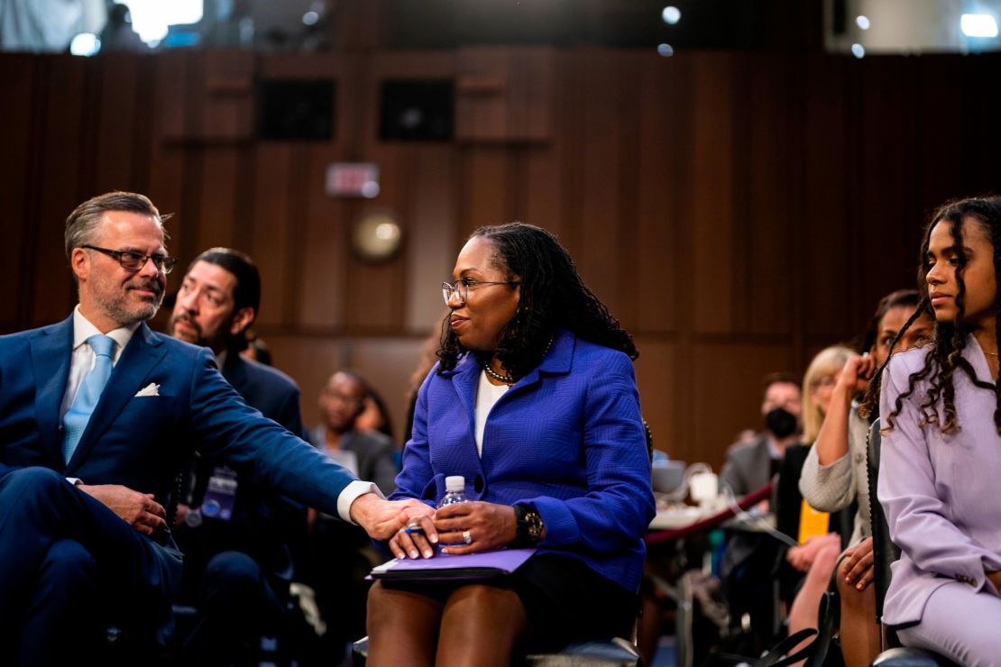 Patrick Jackson, husband of Supreme Court nominee Judge Ketanji Brown Jackson, reaches out to hold her hand as she sits in the audience area with her family during her Senate Judiciary Committee confirmation hearing on Capitol Hill on March 21, 2022 in Washington.