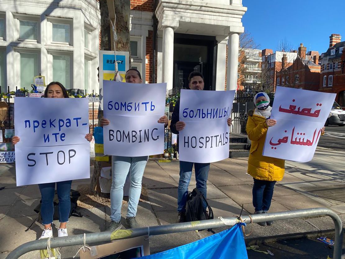 Dr. Hamza al-Kateab (second from left) and fellow demonstrators outside the Russian Embassy in London holding signs in English, Arabic and Russian.
