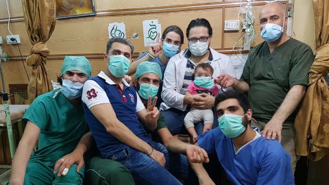 Dr. Hamza al-Kateab (holding daughter Sama) with his medical colleagues in al-Quds hospital, Aleppo.