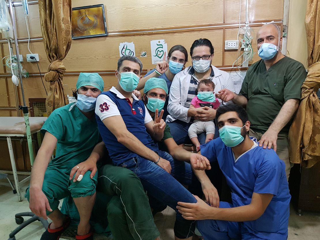 Dr. Hamza al-Kateab (holding daughter Sama) with his medical colleagues in al-Quds hospital, Aleppo.