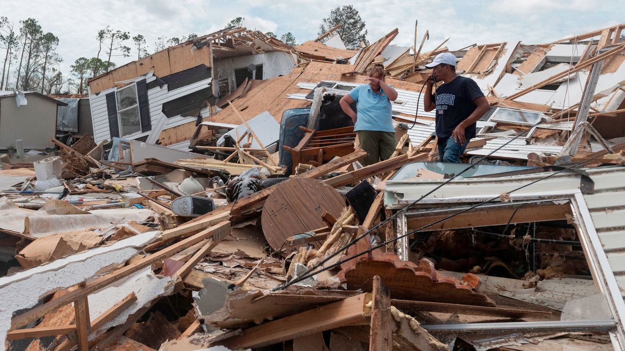 In this August 27, 2020, file photo, a couple sift through what remains of their destroyed mobile home following Hurricane Laura in Lake Charles, Louisiana.