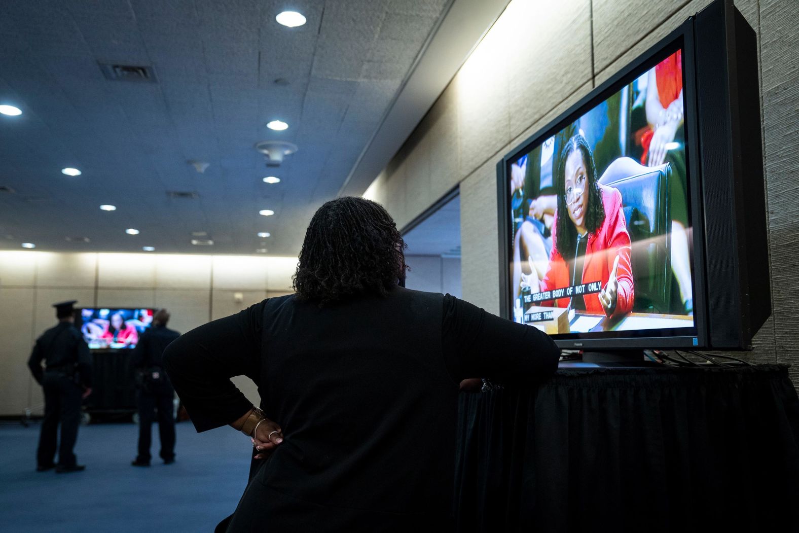 A woman watches a television on Capitol Hill that was streaming Jackson's hearing on March 22.