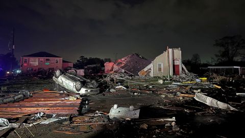 A car lies overturned among debris in the Arabi neighborhood after a large tornado struck near New Orleans Tuesday.