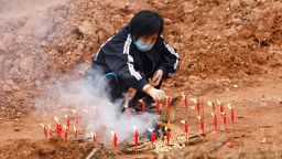A woman takes part in a Buddhist ceremony in honor of the plane crash victims, in a field near Wuzhou, close to the crash site, on March 22.