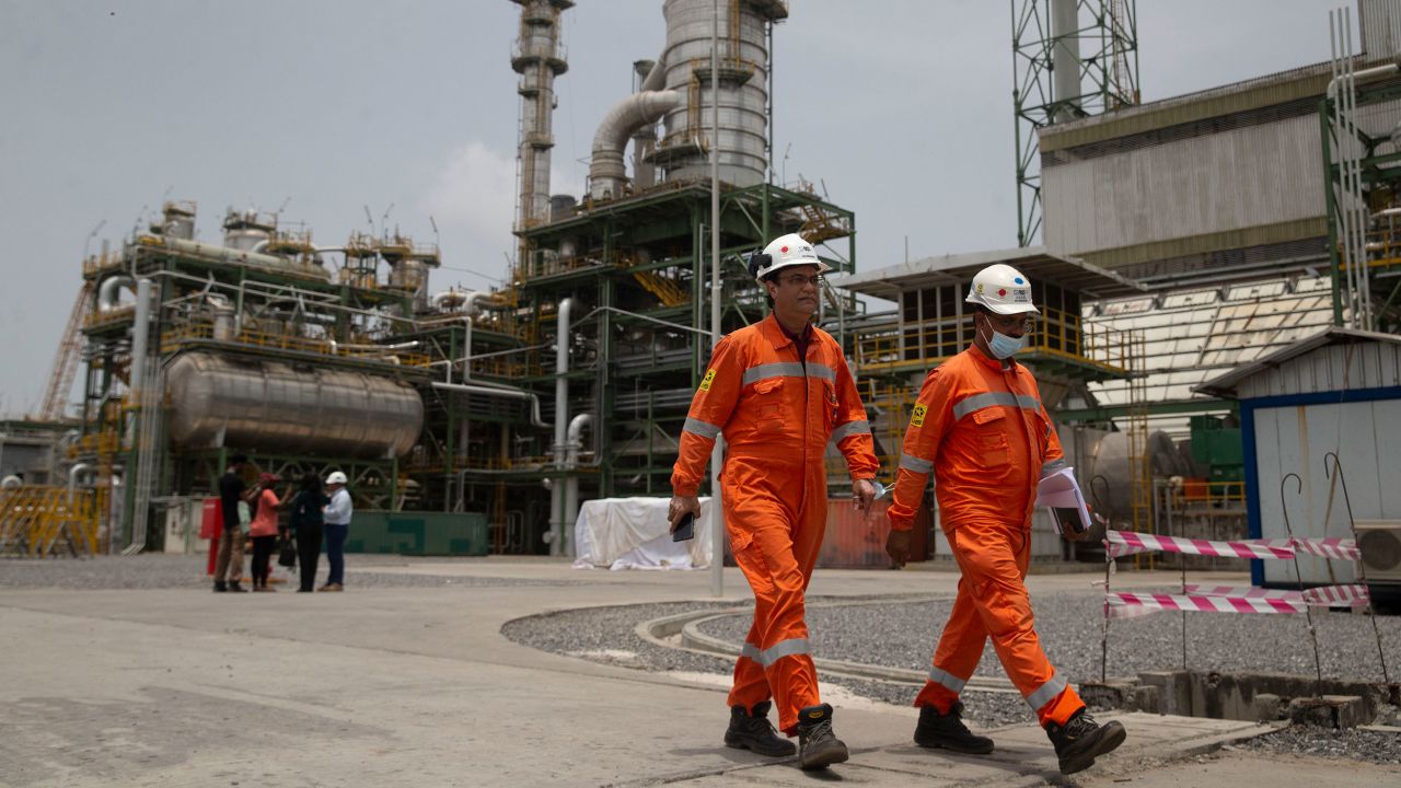 Workers walk past the newly inaugurated Dangote fertilizer plant in Lagos, Nigeria.