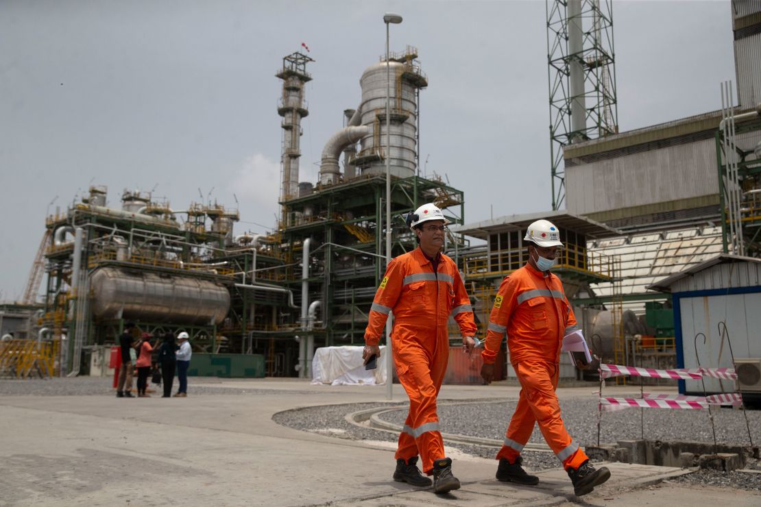Workers walk past the newly inaugurated Dangote fertilizer plant in Lagos, Nigeria. 
