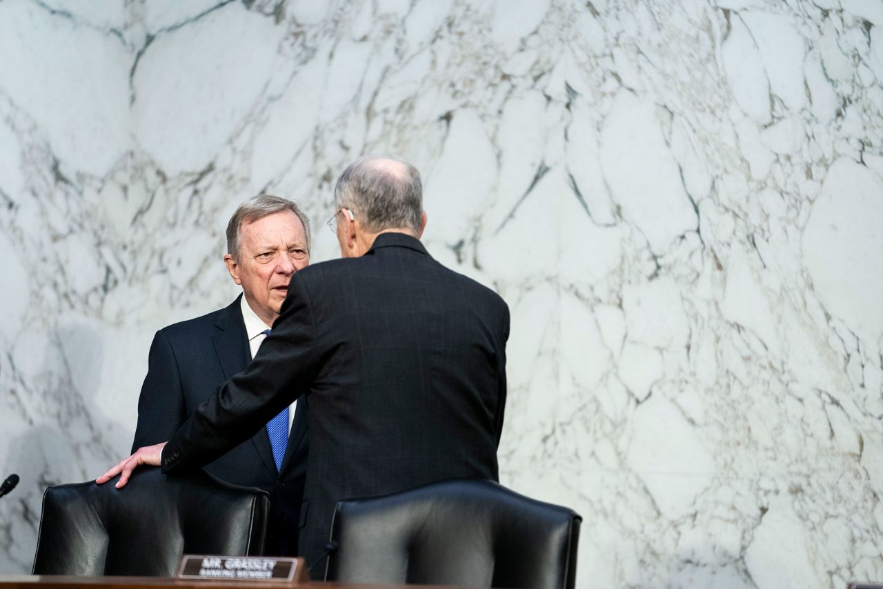 Durbin and Grassley talk before the start of proceedings on March 23.