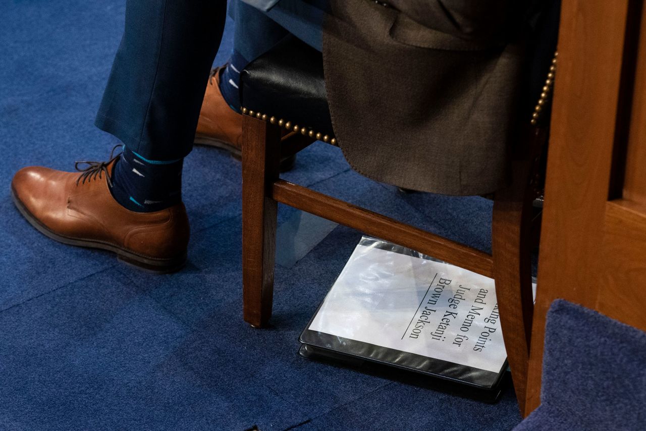 A Senate staffer sits next to a binder with the title "Talking Points and Memo for Judge Ketanji Brown Jackson."